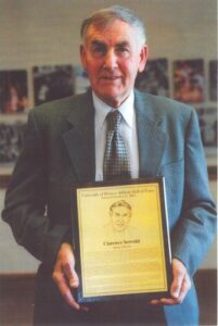 Clarence Servold posed with his University of Denver Athletic Hall of Fame award