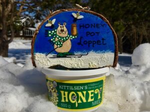 Honey Pot Loppet hand-painted wooden medal and a pot of honey. 