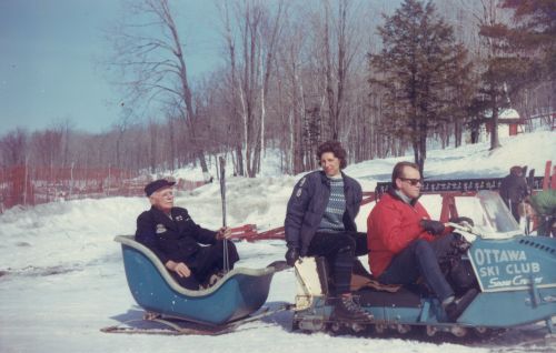 Sigurd Lockeberg being pulled behind an Ottawa Ski Club Snow Cruiser (snowmobile). Photo taken on February 26, 1967 at Camp Fortune