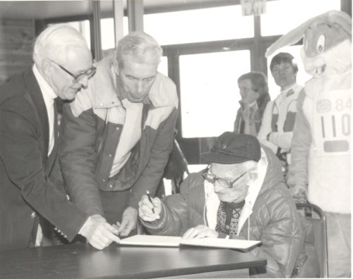 Mr. German, Rae Grinnell (Canadian Ski Museum Chair), and Jackrabbit signing guestbook at "Jackrabbit 110" fundraising event during 1984 Winterlude - Dows Lake Pavilion, Ottawa, ON