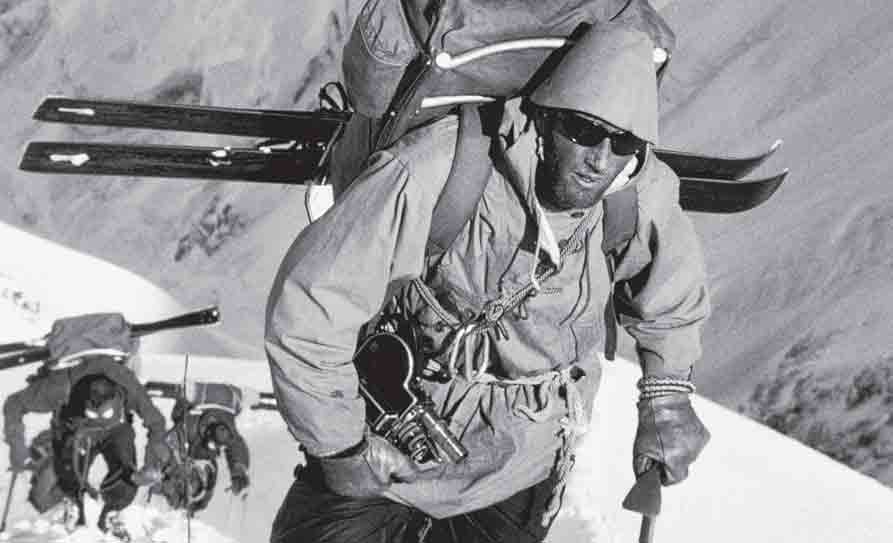 Hans Gmoser, with skis, ice axe and camera leads his group up Mount McKinley in 1963.